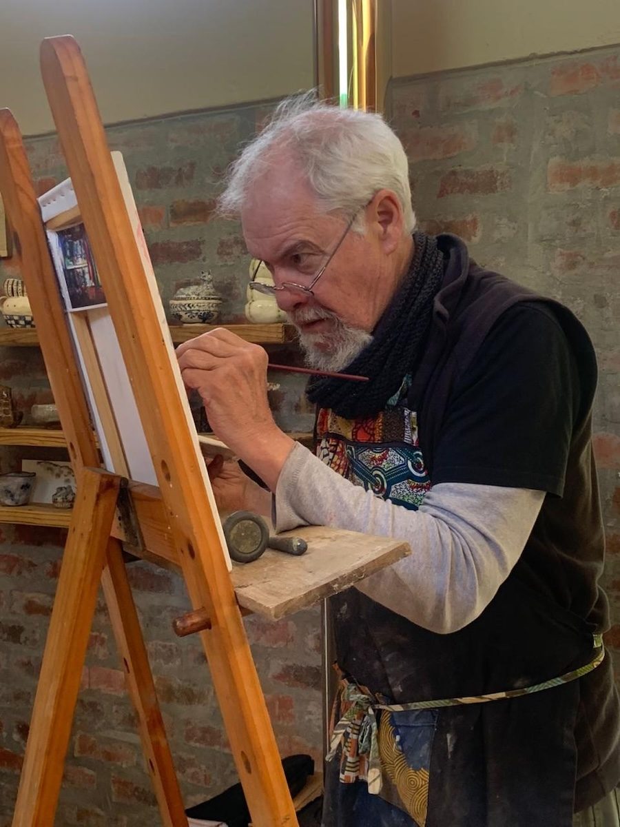 Evan Oberholster painting at his easel in the studio