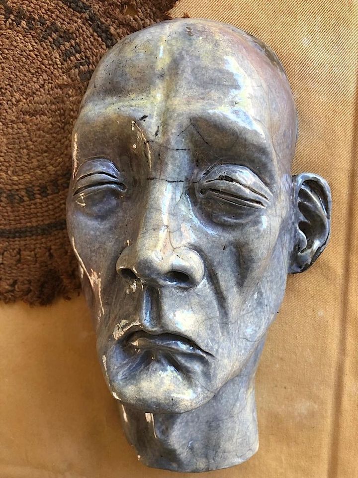 A Serious Man by Evan Oberholster — grey glazed ceramic head with closed eyes and a sculpted ear