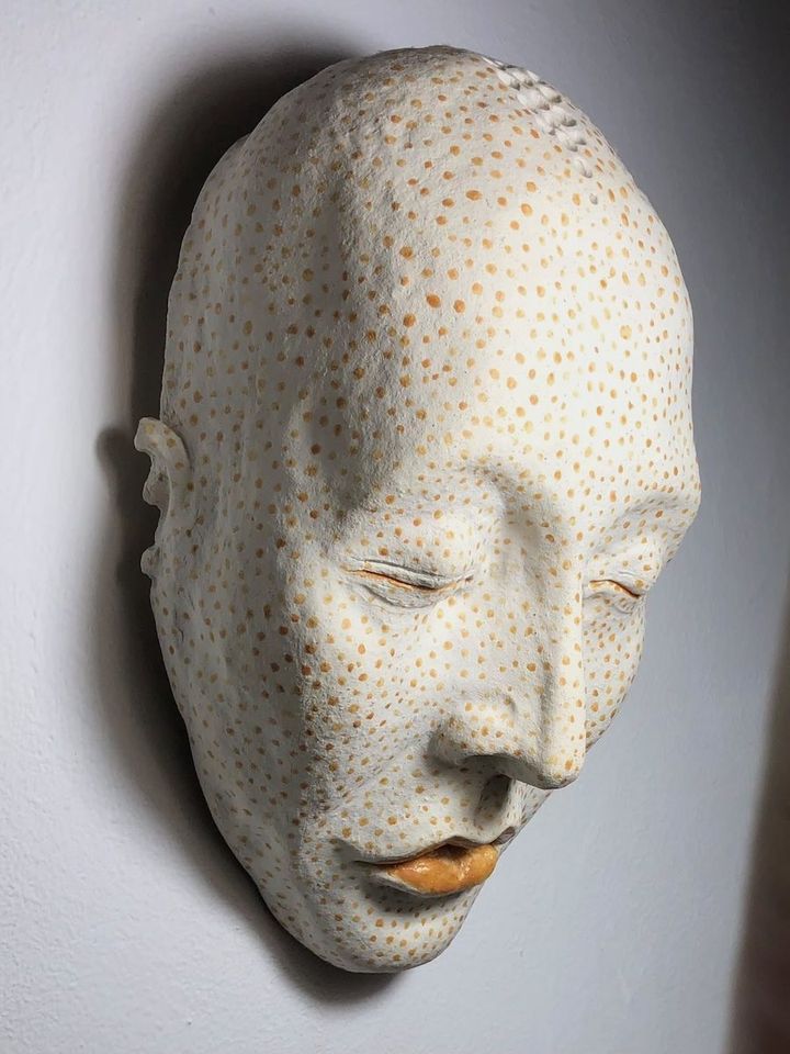 Dotty by Evan Oberholster — white ceramic mask with orange dots and orange lips, eyes closed