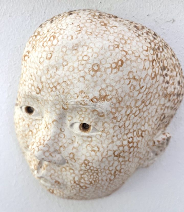 Little One by Evan Oberholster — white ceramic head patterned with small brown rings